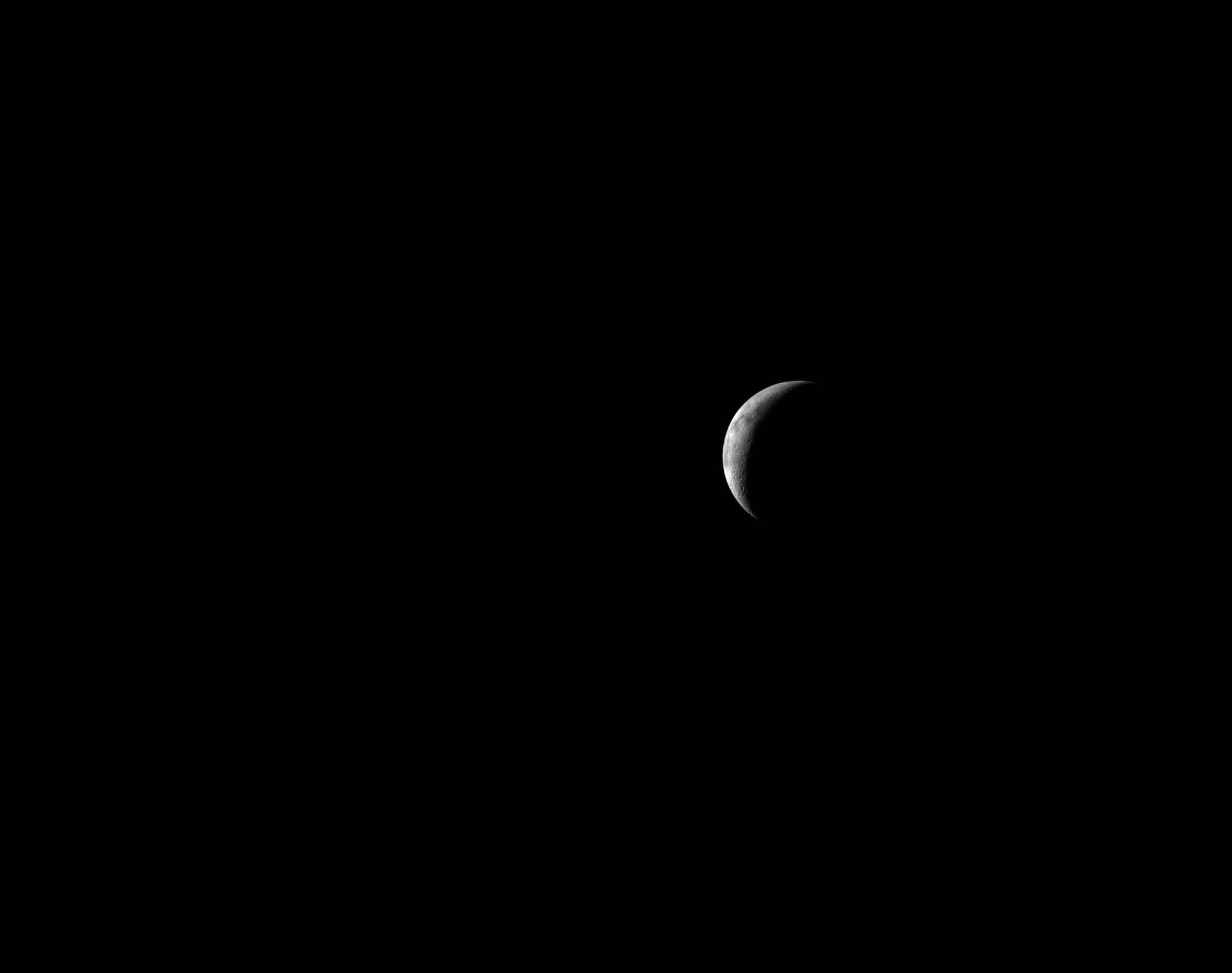 A thin lunar crescent photographed from Orion as the crew travels back toward Earth